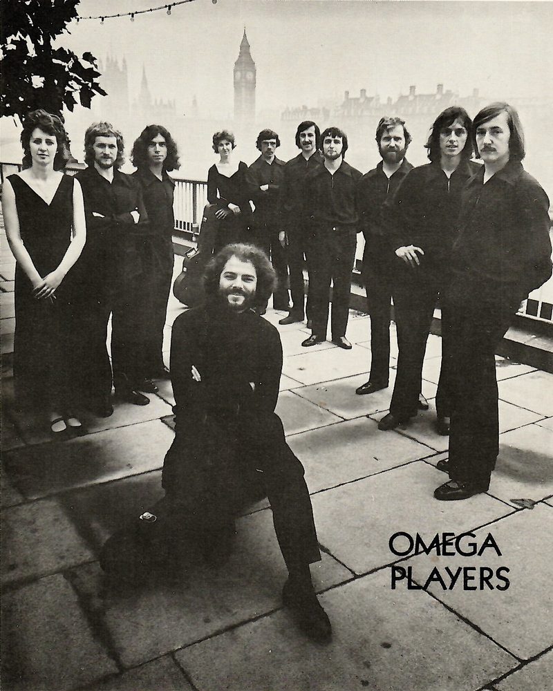 Black-and-white publicity photograph of the Omega Players, a group of young musicians in dark clothes standing on a London rooftop.
