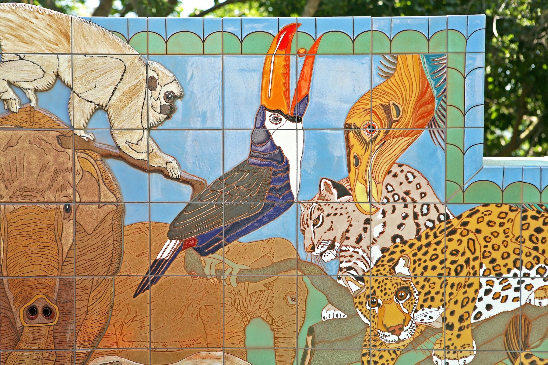 The fountain's back wall: an elephant, a toucan, a jaguar and a snow leopard, a pale monkey and birds in hand-glazed tile.