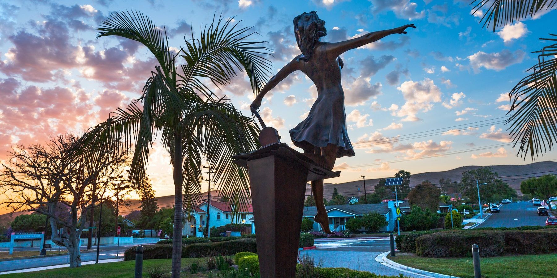 Stepping Out, a twelve-foot bronze dancer, on the plaza at Ventura College at sunset.