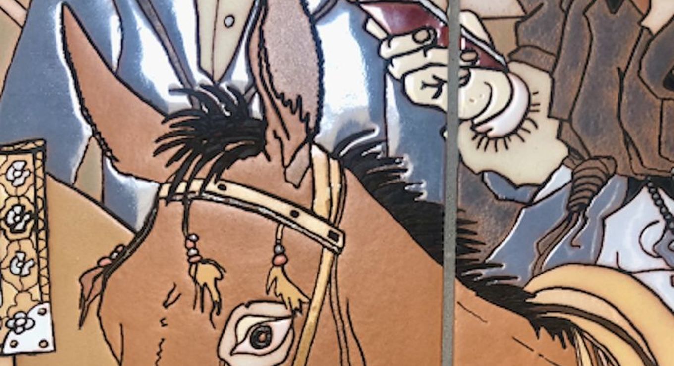 Close detail of the fired surface: a horse's head in the mural, showing the raised unglazed resist lines holding separate pools of glossy brown, cream and slate glaze, with a grout joint running through.