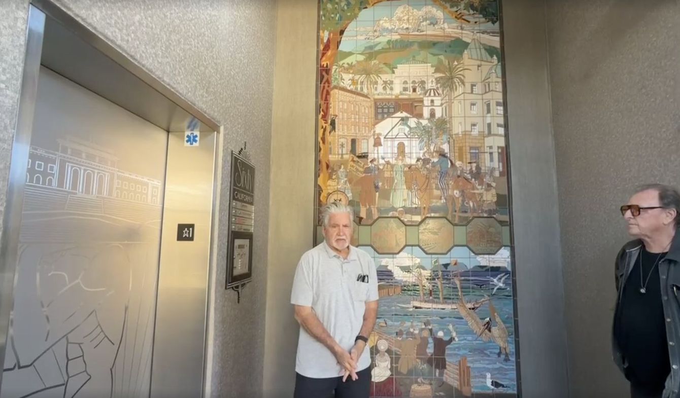 Dan Frederickson and Michael O'Kelly standing in the entry lobby at 60 California Street, with Las Palmas on the wall between them.