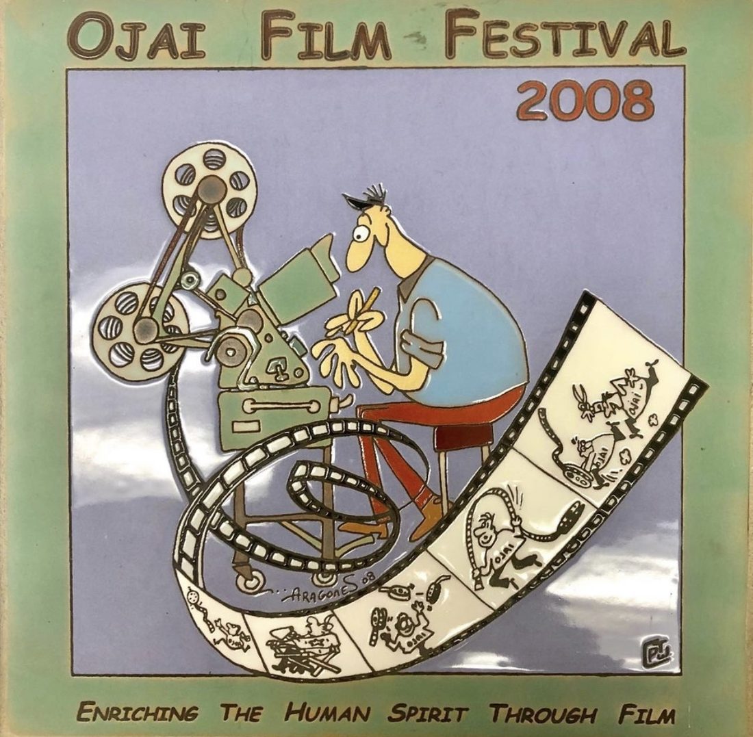 Ceramic plaque for the Ojai Film Festival 2008, with a cartoon figure riding a reel of film, and the line Enriching the human spirit through film.