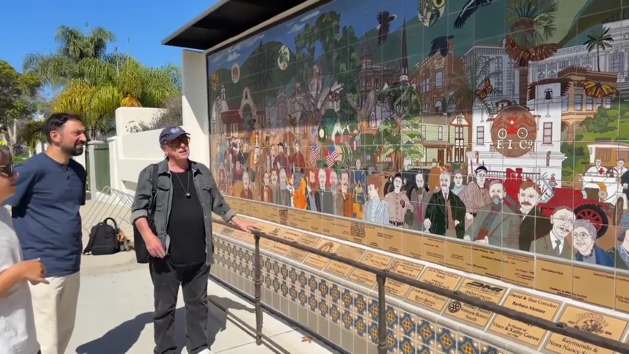 Michael O'Kelly at the mural, explaining it to visitors.