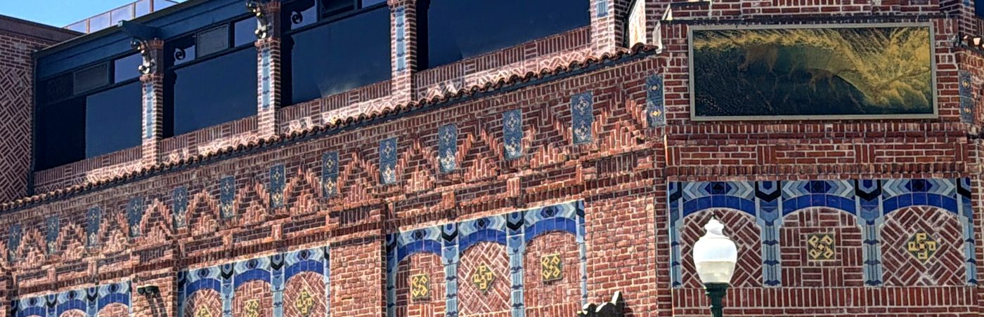 The new top floor of the Watermark, set back above the old brick front, with tile bands that match the floors below.