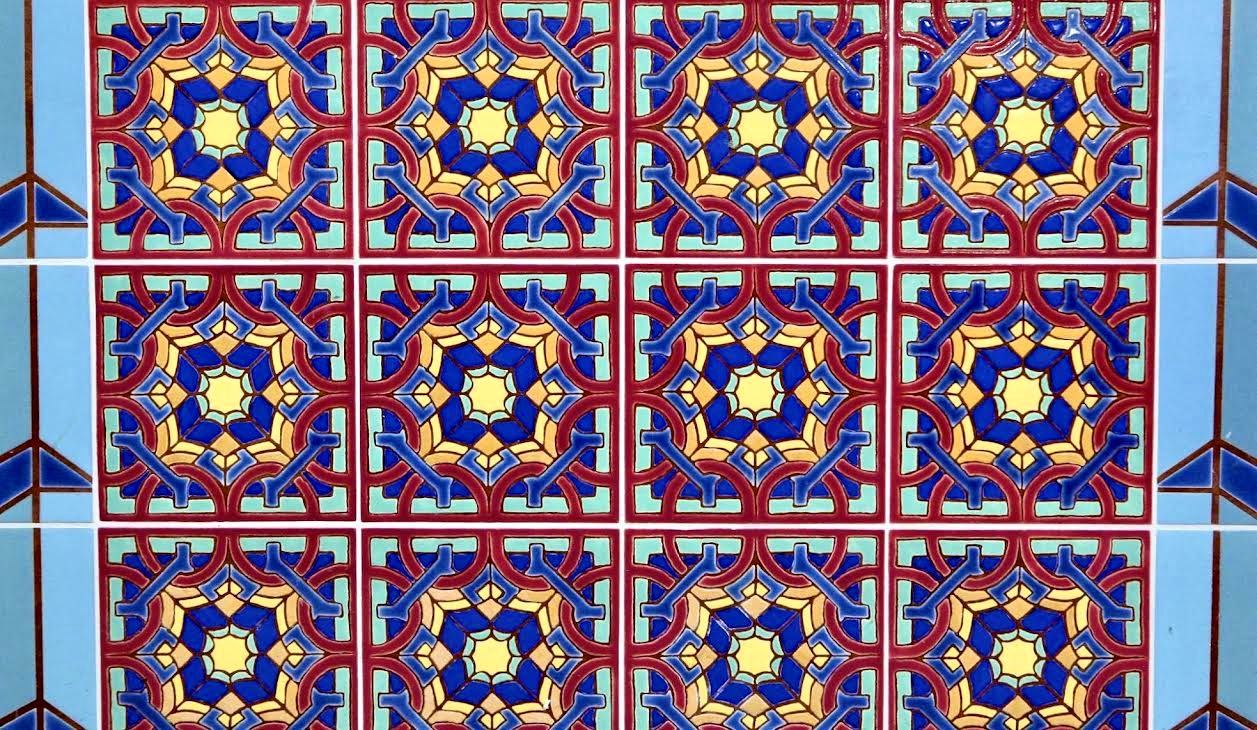 A panel of square tiles, each an eight-pointed star in cobalt, gold and red on a blue ground, photographed by Michael O'Kelly.