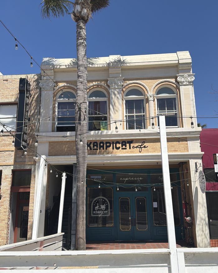 The Kaapicat Caf&eacute; building on Main Street, Ventura: a cream and ochre Italianate facade with four arched upper windows, re-created from a vintage photograph of the building.